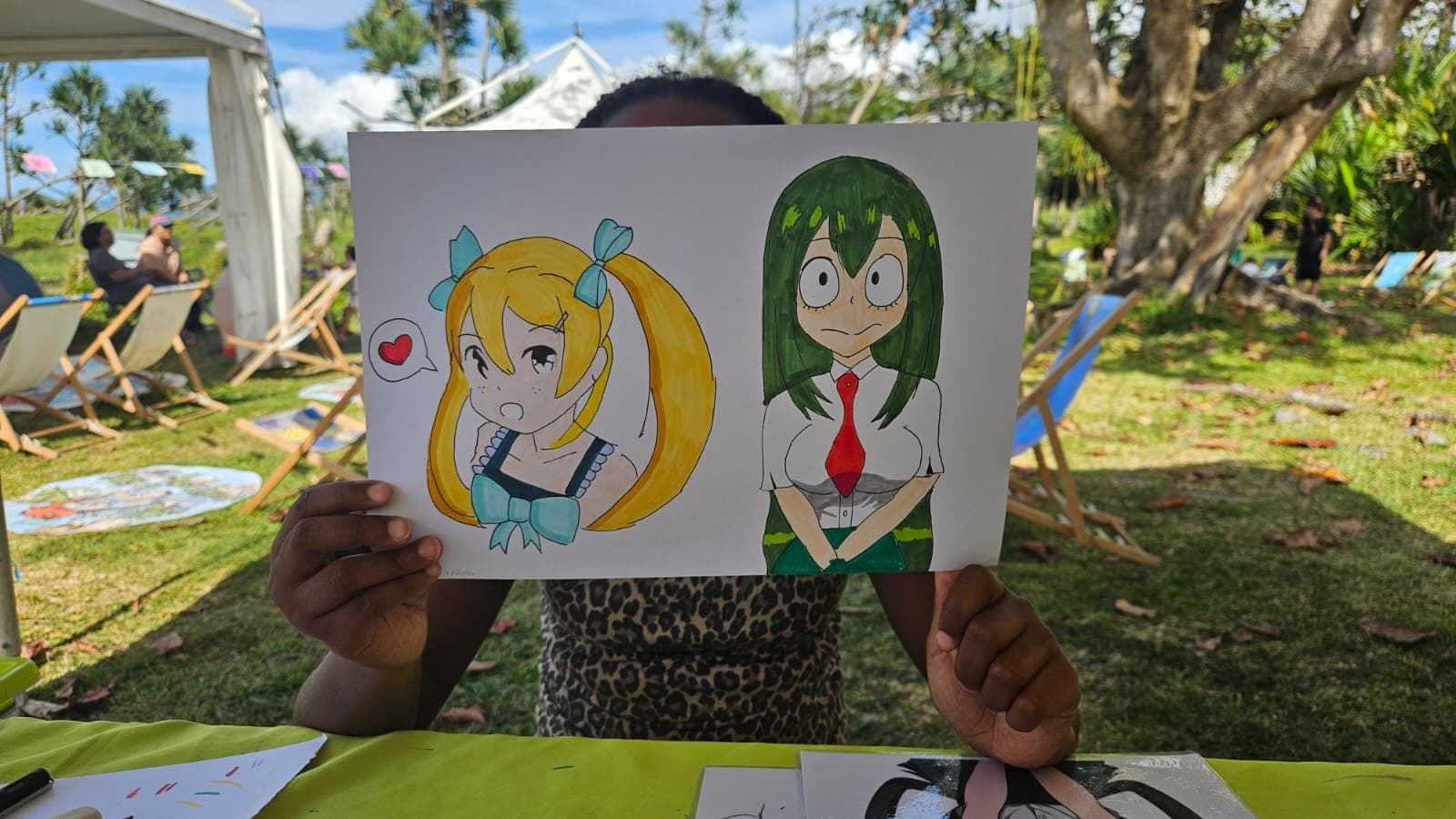 Enfant montrant fièrement ses dessins manga après un atelier à La Réunion